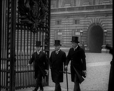 Three Male British Members of Parliament Walking Away from Buckingham Palace, Passing..., 1924. Creator: British Pathe Ltd.