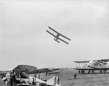 Avro 504 biplane flying very low over parked aircraft at the RAF Pageant, Hendon, London, 1927. Artist: Aerofilms.