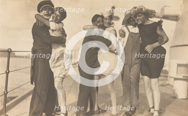 Sailors, some in drag, pose as three couples on the deck of a ship, (between 1920 and 1929?). Creator: Unknown.