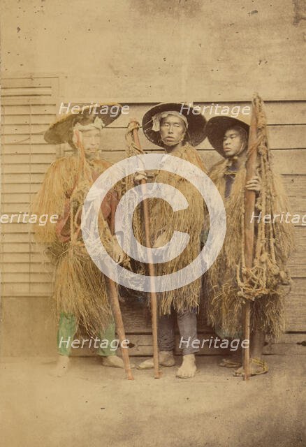 Three Japanese men in grass robes and wide-brimmed hats, 1868-1880. Creator: Felice Beato.