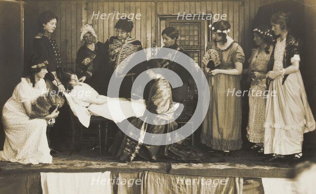 Amateur actors, some in drag, on stage attending to the death of a female character, [1910-1919?]. Creator: Unknown.