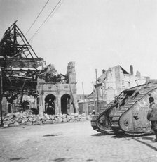 British tank in front of ruined buildings, Peronne, France, World War I, c1916-c1918. Artist: Nightingale & Co