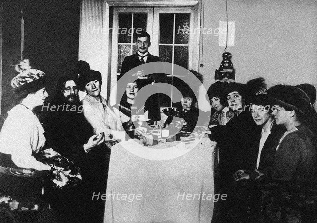 Rasputin (second from left) at the meal among His Admirers, c. 1910.