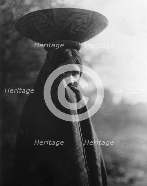 Maricopa girl, half-length portrait, standing, facing slightly right, wrapped in blanket..., c1907. Creator: Edward Sheriff Curtis.