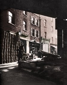 Fruit baskets piled against houses at Borough Market, London, 1926-1927. Artist: Whiffin.