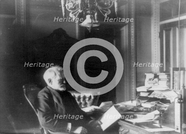 Benjamin Franklin Tracy, Secretary of the Navy, half-length portrait..., looking at paper, c1890. Creator: Frances Benjamin Johnston.