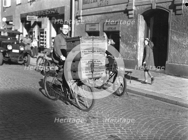 Delivery boy with bread boxes from the Lisa Öhman Bakery, Stockholm, Sweden, 10th October 1942. Artist: Karl Sandels