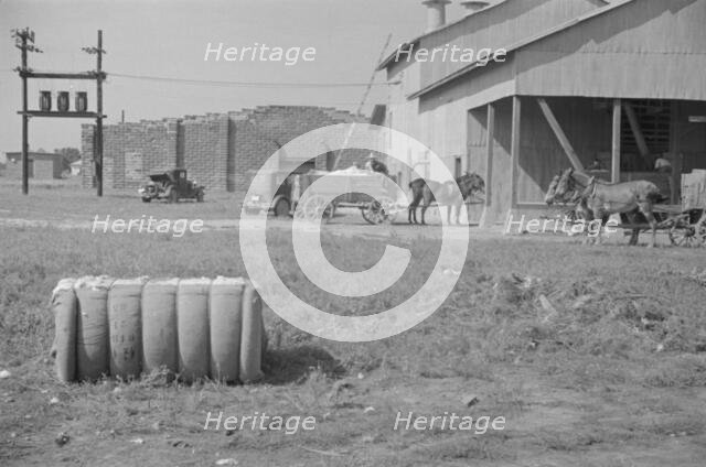 At the cotton gin, Cotton gin and wagons, Hale County, Alabama, 1936. Creator: Walker Evans.