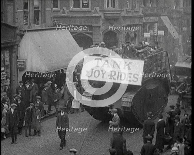 People Riding on Top of a Tank Down the Street. The Tank Bears a Sign Reading 'Tank Joy Rides', 1920 Creator: British Pathe Ltd.