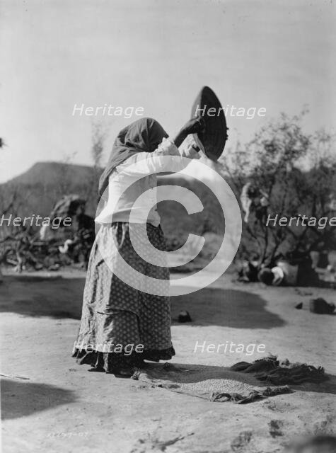 Papago cleaning wheat (Winnowing wheat), c1907. Creator: Edward Sheriff Curtis.