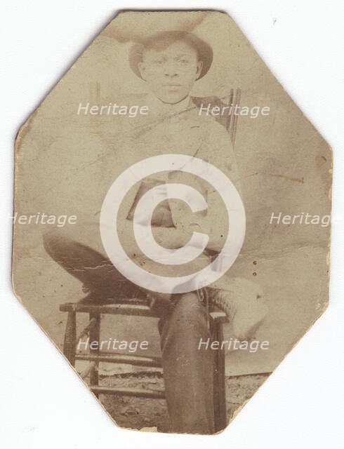 Photographic print of a man in suit sitting on a chair with right leg crossed, late 19th-early 20th  Creator: Unknown.