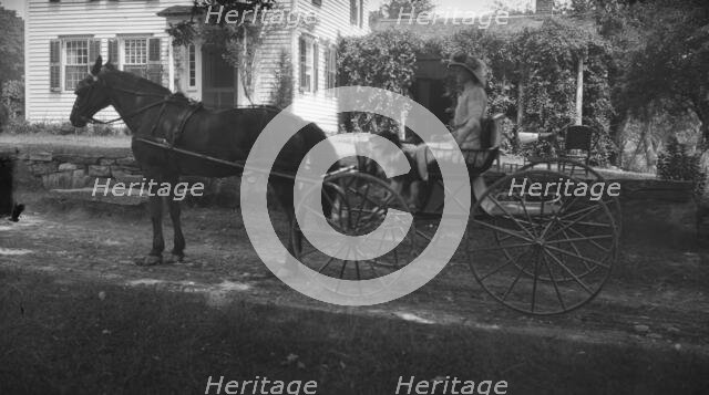 Tarbell, Ida, Miss, with dog, in a horse-drawn wagon, 1912 or 1913. Creator: Arnold Genthe.
