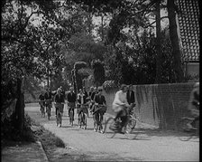 A Group of Young Female Civilians Wearing School Uniforms Riding Bicycles Along a Dusty Road, 1920. Creator: British Pathe Ltd.