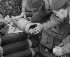 Allied Soldiers Loading Leaflets, Calling the Enemy to Surrender Into an Artillery Shell, 1944. Creator: British Pathe Ltd.