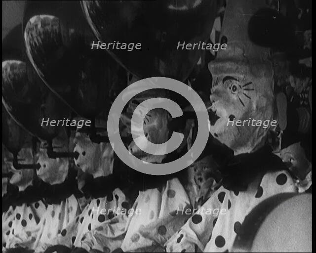 A Row of Clown Figures With Balloons Forming Part of a Game, 1924. Creator: British Pathe Ltd.