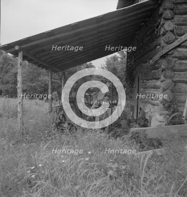 Farm machinery drawn under cover of old tobacco barn, Person County, North Carolina, 1939. Creator: Dorothea Lange.