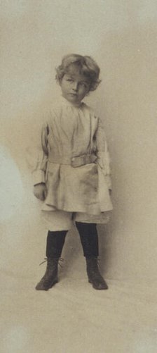 Portrait of a young boy standing in short pants and belted shirt, c1900. Creator: Misses Selby.