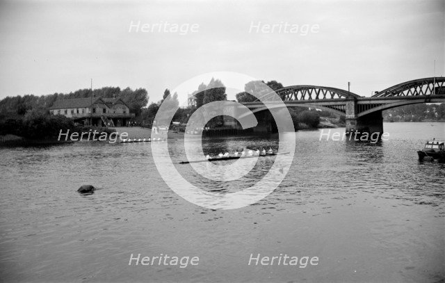 A rowing eight approaches Barnes Bridge, Chiswick, London, c1945-c1965. Artist: SW Rawlings