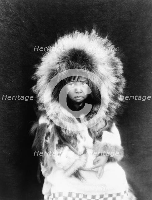 Noatak child, three-quarter length portrait, seated, facing front, c1929. Creator: Edward Sheriff Curtis.