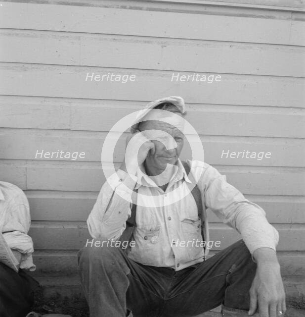 Bindle stiff, used to be logger, Side of Pastime Café, Tulelake, Siskiyou County, California, 1939. Creator: Dorothea Lange.