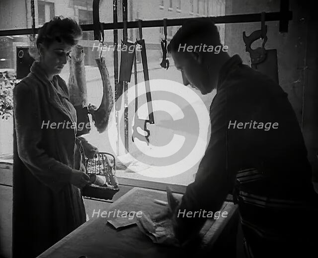 A Woman Buying Meat at a Butcher's Shop, 1942. Creator: British Pathe Ltd.