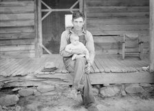 Mr. Whitfield, tobacco sharecropper, with baby on front porch, North Carolina, Person County, 1939. Creator: Dorothea Lange.