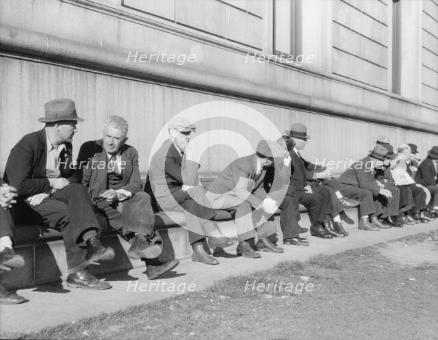 Unemployed men sitting on the sunny side of the San Francisco Public Library, California, 1937. Creator: Dorothea Lange.