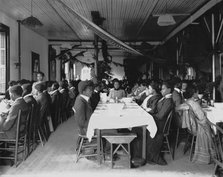 Interior view of dining hall, decorated for the holidays, with students... Tuskegee Institute, c1902 Creator: Frances Benjamin Johnston.