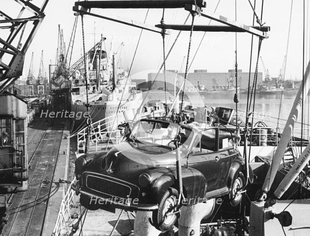 Morris Minor convertible craned onto ship for export at Cardiff docks. Creator: Unknown.
