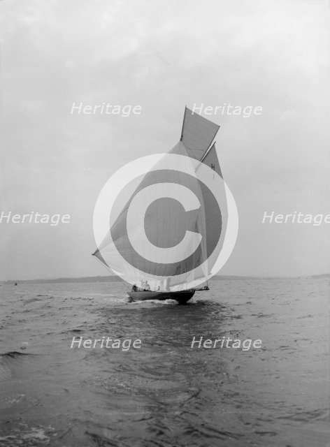The 8 Metre class 'Antwerpia IV' sailing under spinnaker, 1912. Creator: Kirk & Sons of Cowes.