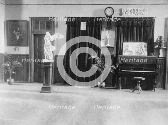 Room with piano, potted palms, and classical statues and friezes, (1899?). Creator: Frances Benjamin Johnston.