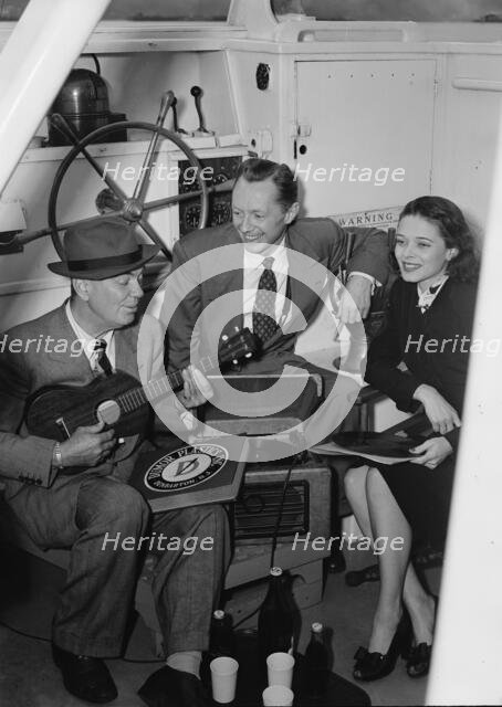 Portrait of Cliff Edwards, Betty Brewer, and Frank..., Ukelele Lady (yacht), Hudson River, NY, 1947. Creator: William Paul Gottlieb.