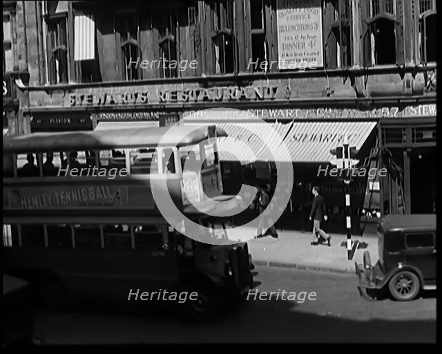 Exterior of Stewards Restaurant and London Traffic. Sign on the Side of a Bus Reads..., 1931. Creator: British Pathe Ltd.