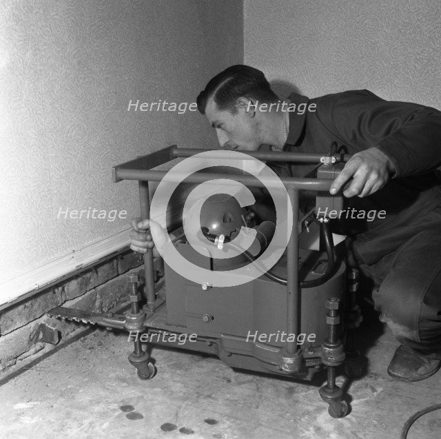 Installing a damp proof course in a house in Goldthorpe, South Yorkshire, 1957.  Artist: Michael Walters