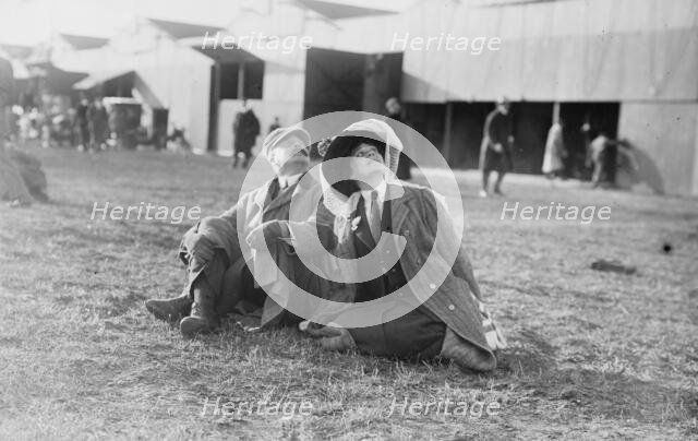 Mrs. Payne Whitney with unidentified gentleman seated on flying field of aviation meet, 1910. Creator: Bain News Service.