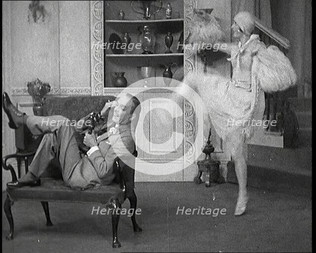 Renee Gadd Dancing Around George Grossmith Who Is Desperately Trying to Make a Phone Call..., 1920s. Creator: British Pathe Ltd.