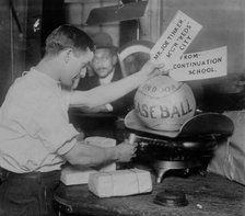Medicine ball being weighed by Post Office employee; shipping tags read: Mr. Joe Tinker..., 1913. Creator: Bain News Service.