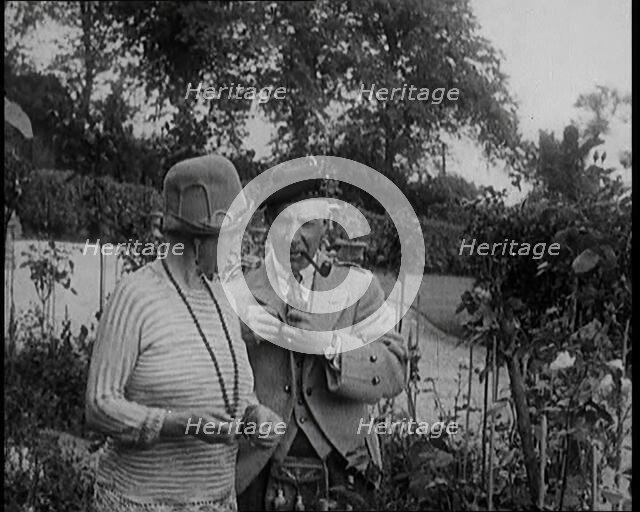 Sir Harry Lauder Giving Flowers to His Wife, Lady Ann Lauder, at Home in Scotland, 1920s. Creator: British Pathe Ltd.