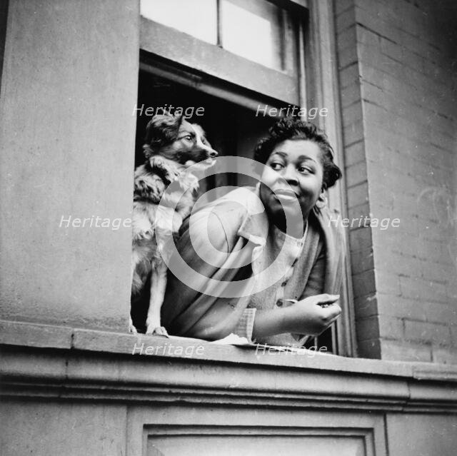 A woman and her dog in the Harlem section, New York, 1943. Creator: Gordon Parks.
