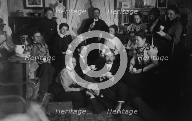 Group portrait of friends at social gathering, seated and standing with tea cups..., c1890 - 1910. Creator: Frances Benjamin Johnston.