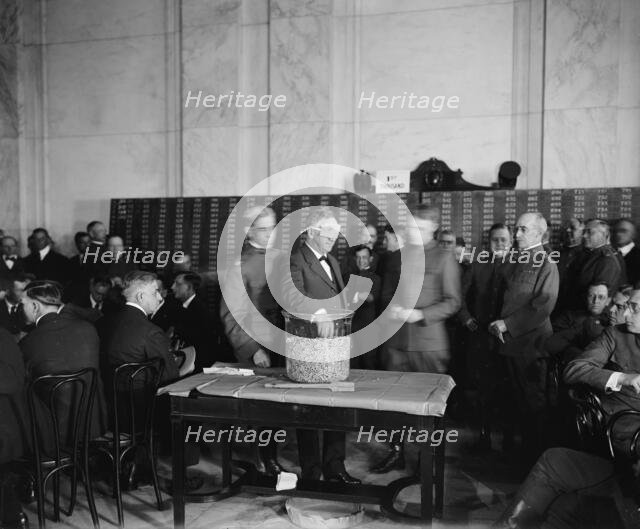 Sec. of the Navy Josephus Daniels drawing draft capsules, between 1910 and 1920. Creator: Harris & Ewing.