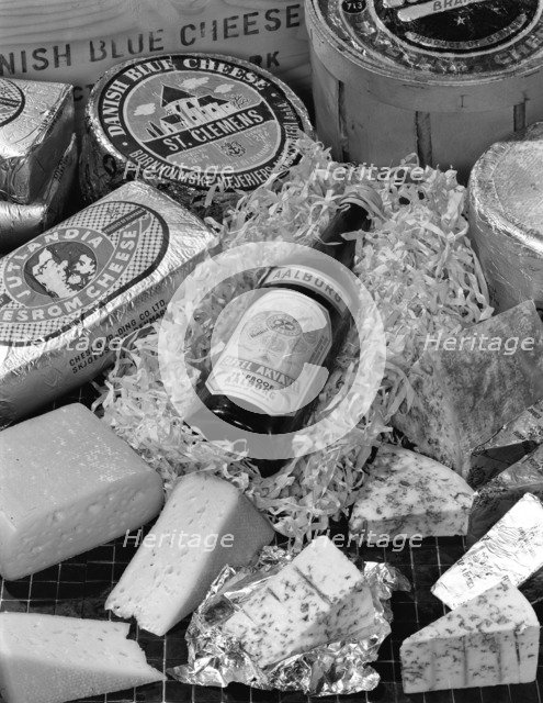 A selection of Danish cheeses and a bottle of Aalborg aquavit, 1963. Artist: Michael Walters