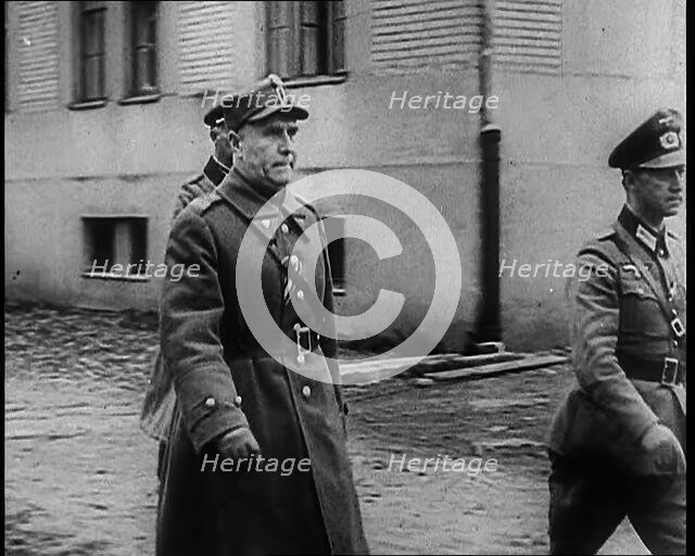 A Male Polish Army Commander Walking Past the Corner of a Large Building With Two Male... 1939. Creator: British Pathe Ltd.
