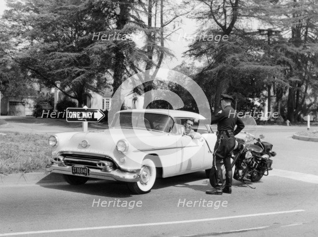 An Oldsmobile at the corner of an American street, 1954. Artist: Unknown