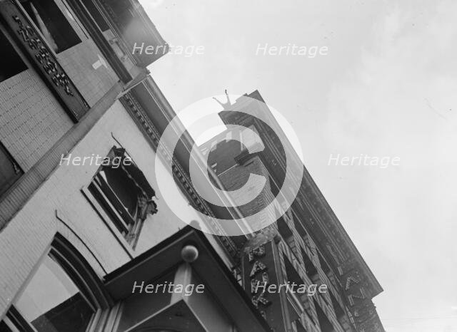 J. Reynolds, Performing Acrobatic And Balancing Acts On High Cornice Above 9th Street, N.W., 1917. Creator: Harris & Ewing.