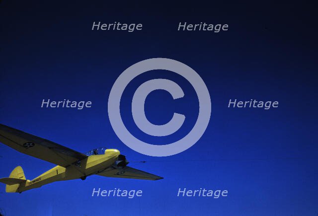 A Marine Corps glider being towed by a power plane from Page Field, at Parris Island, S.C., 1942. Creator: Alfred T Palmer.