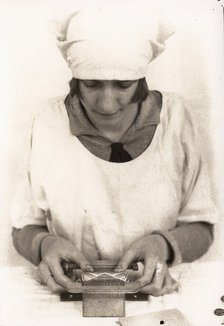 A woman seals the wrapper of a tube of Rowntree clear gums, Rowntree factory, York, 1929. Artist: Unknown