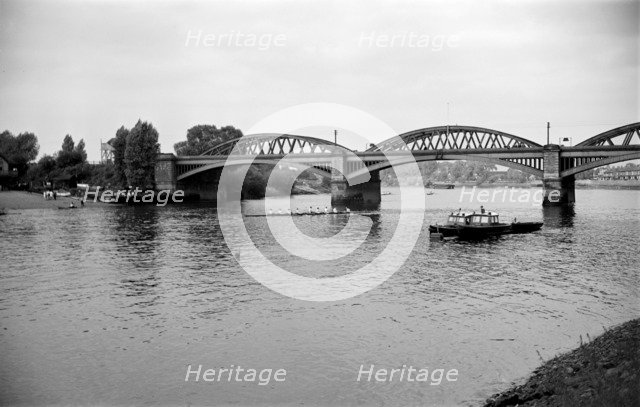 A rowing eight passes under Barnes Bridge, Chiswick, London, c1945-c1965.  Artist: SW Rawlings