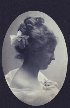 Oval portrait of woman with a flower in her hair and a corsage on her dress, c1900. Creator: Fannie L. Elton.