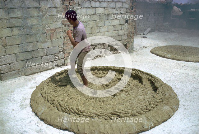 Treading clay for pottery in Tunisia. Artist: CM Dixon Artist: Unknown